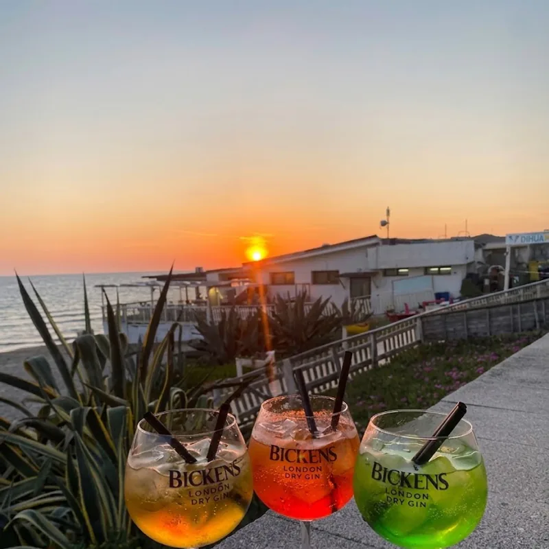 Tre gin tonic mentre il sole scende in mare