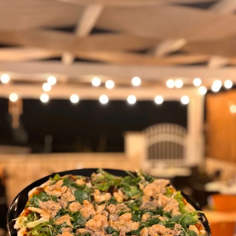 Pizza al salmone e rucola servita di sera