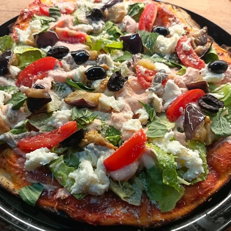 Una pizza intera appena sfornata con verdure e mozzarella