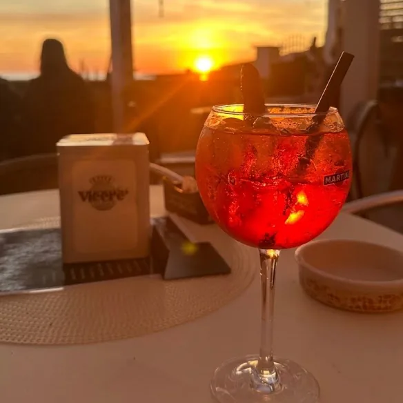 Uno spritz in terrazza mentre il sole tocca l'orizzonte